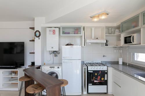 a kitchen with white appliances and a stove top oven at Jion in Mar del Plata