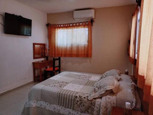 1 dormitorio con cama, escritorio y ventana en Estrella de Mar: Departamento en Progreso en Progreso