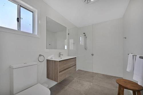 a white bathroom with a toilet and a sink at The Elm Apartments - The Orange Room in Orange