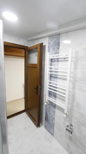 a bathroom with a wooden door and a walk in shower at Hotel Ave Maria in Selçuk
