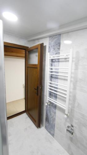 a bathroom with a wooden door and a walk in shower at Hotel Ave Maria in Selcuk