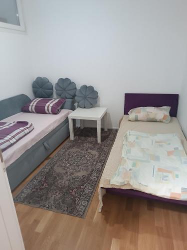 una camera da letto con due letti e un tavolo di Mercy Deluxapartment a Visoko
