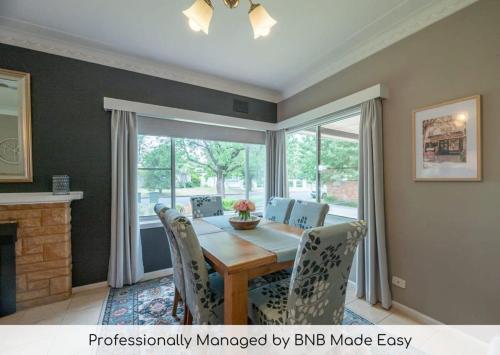 a dining room with a wooden table and chairs at Roycox Cottage - Charming Escape, Fireplace in Dubbo