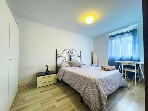 a bedroom with a bed and a desk and a window at Alojamiento cerca de la Playa in Valencia