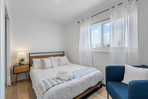Habitación blanca con cama y ventana en The Hidden Loft I 5-min Walk 2 Beach I DT I 55 TV, en Sylvan Lake