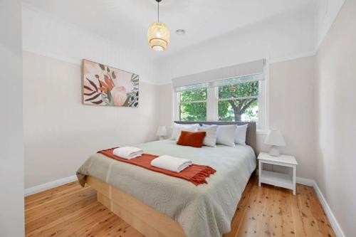 um quarto com uma cama grande com paredes brancas e uma janela em Amarde - Contemporary Heritage Fusion, Fireplace em Orange