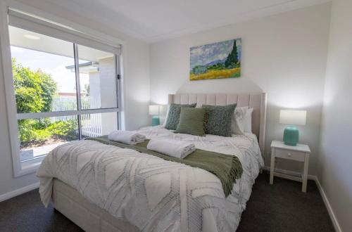 a bedroom with a large bed with a window at The Hideaway - Close to Zoo & Golf Club in Dubbo