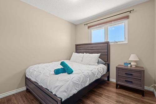 a bedroom with a bed with a blue pillow on it at Bahama Breeze I Hot Tub I Pool I 5 Bedroom in Drumheller