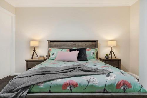 a bedroom with a bed and two lamps on tables at Crooked Lane Apartment - CBD, Stylish & Central in Wagga Wagga