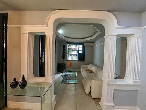 Hotel Filha do Cacique في بيليم: غرفة معيشة مع أريكة بيضاء وطاولة زجاجية
