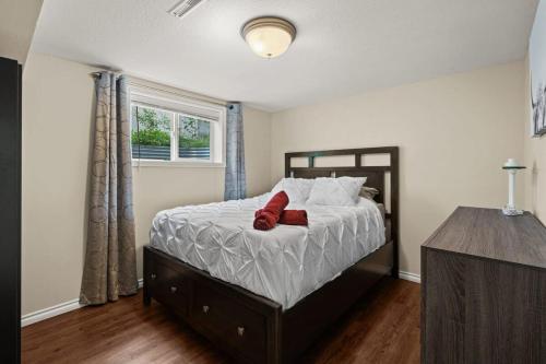 a bedroom with a bed with two red pillows on it at Bahama Breeze I Hot Tub I Pool I 5 Bedroom in Drumheller