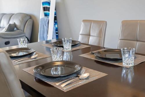 a table with black plates and silverware on it at Bahama Breeze I Hot Tub I Pool I 5 Bedroom in Drumheller