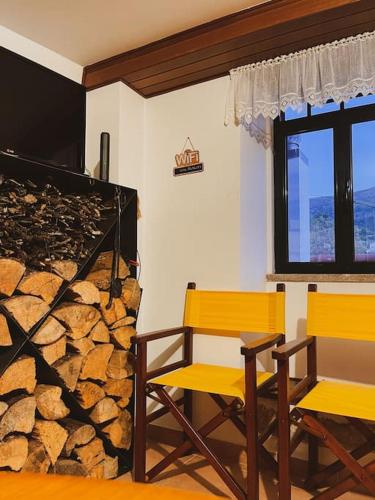 two yellow chairs in a room with a fireplace at Cantinho de Aldeias in Gouveia