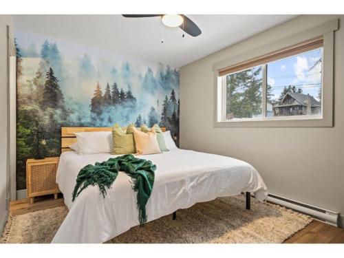 a bedroom with a bed with a painting on the wall at Evergreen Escape I Fireplace I Walk to the Lake in Invermere