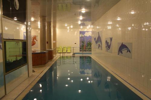 a swimming pool in a building with lights on the wall at Wellness Hotel Szindbád in Balatonszemes