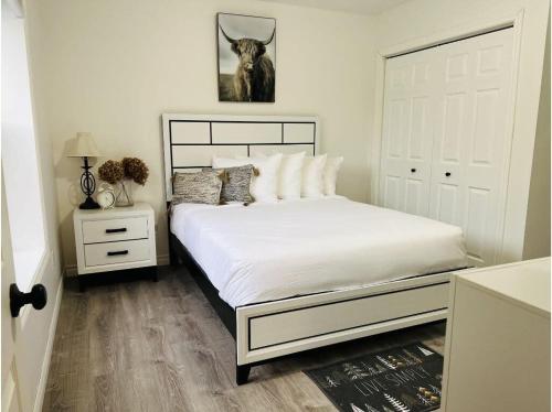 1 dormitorio con cama blanca y puerta blanca en The Artistry I Sled In & Sled Out I Riverside I TV en Bancroft