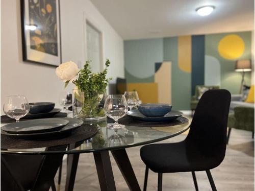 a dining room table with plates and wine glasses at The Artistry I Sled In & Sled Out I Riverside I TV in Bancroft