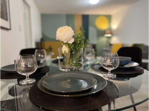 a glass table with plates and glasses and a white rose at The Artistry I Sled In & Sled Out I Riverside I TV in Bancroft