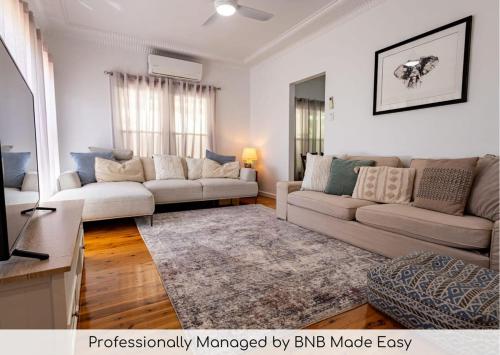a living room with two couches and a rug at Crown Comforts - Family Escape, Firepit in Dubbo