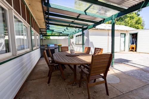 a wooden table and chairs on a patio at Crown Comforts - Family Escape, Firepit in Dubbo