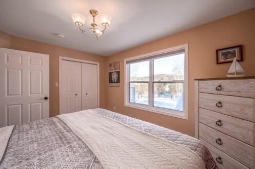 ein Schlafzimmer mit einem Bett, einem Fenster und einer Kommode in der Unterkunft Point Of View I 55 SmartTV I Riverside I Sleeps 5 in Bancroft