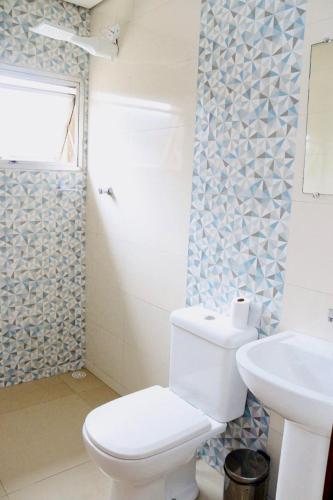 a bathroom with a toilet and a sink at GM Hotel SP in Utinga
