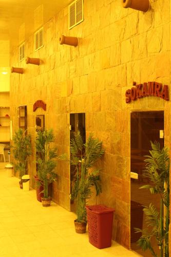 a building with plants in front of a stone wall at Wellness Hotel Szindbád in Balatonszemes