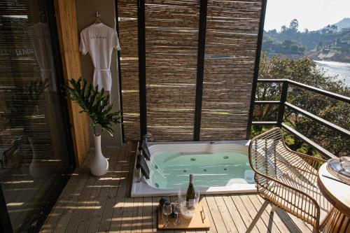 bañera de hidromasaje en una terraza con un vestido en una ventana en La Pausa Hotelbistro en Guatapé