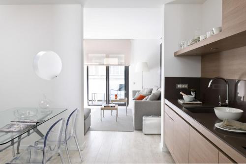a kitchen and living room with a table and chairs at Eric Vökel Boutique Apartments - BCN Suites in Barcelona