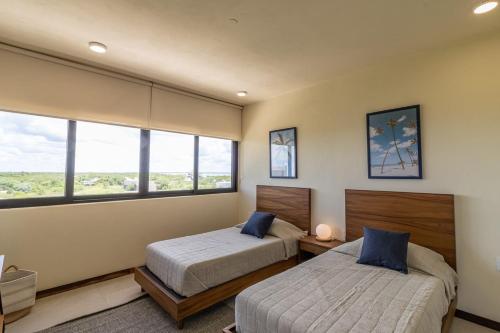 a bedroom with two beds and a large window at Stunning Ocean View Penthouse With Private Pool - B301 in Holbox Island