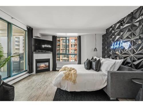 a bedroom with a large bed and a fireplace at The Loki I Patio & BBQ I Sleeps 5 I Downtown I TV in Calgary