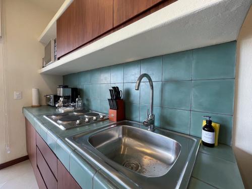 a kitchen with a stainless steel sink and blue tiles at Stunning Ocean View Penthouse With Private Pool - B301 in Holbox Island