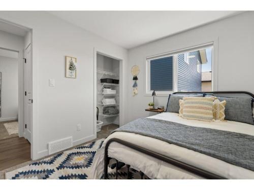 Un dormitorio con una cama grande y una ventana en Centre Peak View I Sleep 8 I 50 TV I Full Kitchen, en Pincher Creek