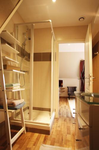 une salle de bain avec une douche en verre dans une chambre dans l'établissement La Cense - Ferme des Tilleuls, à Houplines