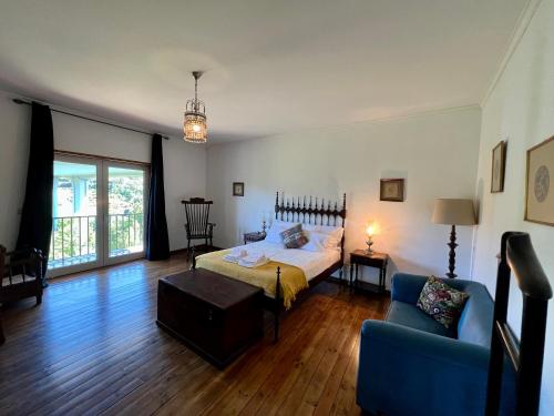 a bedroom with a bed and a blue couch at Quinta do Casarão by VinteOito - Casa de Campo com Piscina in Amarante