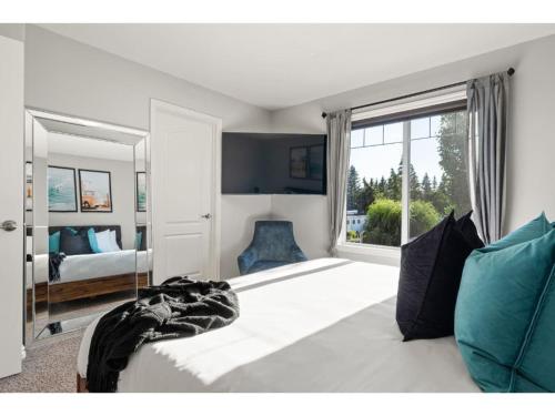 1 dormitorio con sofá, cama y ventana en The Saturday I Sleeps 16 I BBQ & Patio I Fire Pit en Sylvan Lake