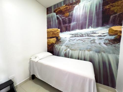 a bedroom with a waterfall mural on the wall at Hotel Bolivariana Plaza Medellin in Medellín