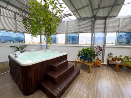 a hot tub in a room with windows at Hotel Bolivariana Plaza Medellin in Medellín