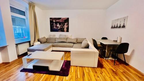 a living room with a couch and a table at DE Apartment in Neu Ulm