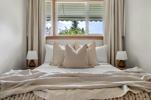 a bedroom with a bed with pillows and a window at The Distillery in Red Deer