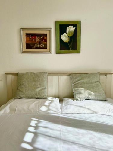 a bedroom with a bed with two pictures on the wall at Nura's - Casa Nina in Alghero
