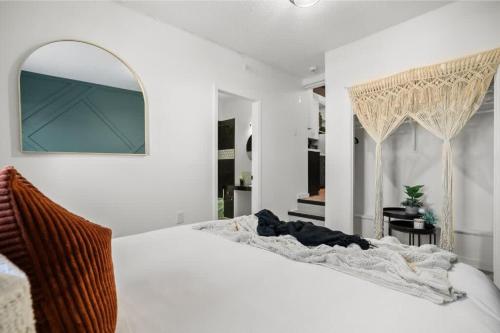 uma cama branca num quarto com um espelho em The Marble em Drumheller
