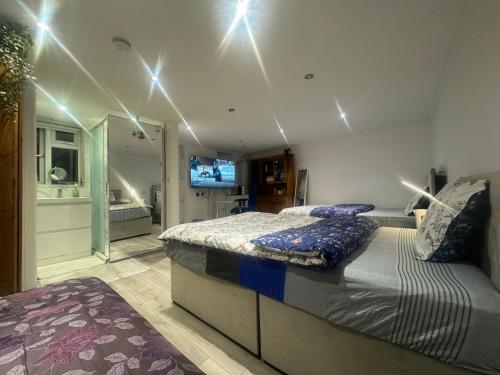 ein Schlafzimmer mit einem Bett und ein Badezimmer mit einem TV in der Unterkunft North Avenue, Guest House, Heathrow Airport-Free Parking in Hayes