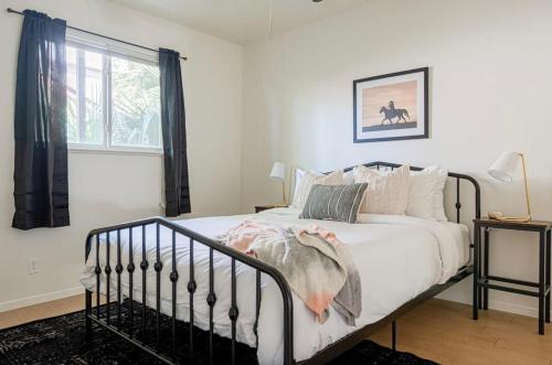 een slaapkamer met een bed met witte lakens en een raam bij Rancho Del Sol l Sleeps 5 l Close to Downtown I TV in Austin
