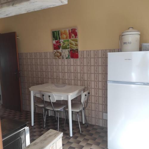 a kitchen with a white table and a refrigerator at Casa Furtado in Burgau