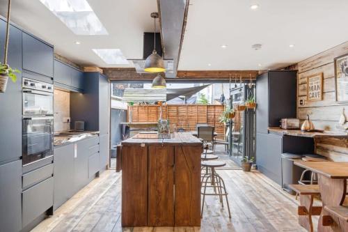 a kitchen with blue cabinets and a wooden island at Stylish House w Free Parking Nr Exeter Centre in Exeter