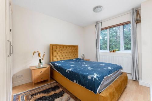 Un dormitorio con una cama con una manta azul. en Tranquility en Cheam