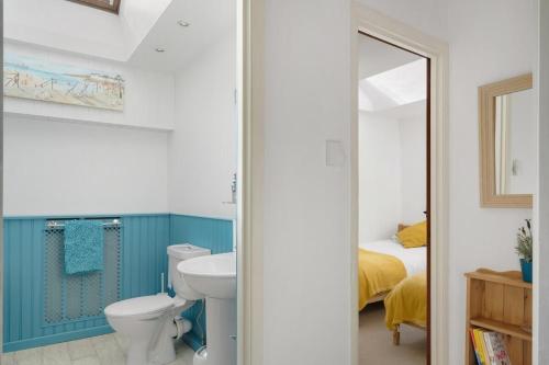 y baño con aseo, lavabo y espejo. en Cosy Cottage Huge Garden w Lake BBQs & Seating en Slapton