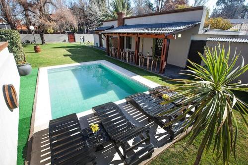a swimming pool with chairs and a house at Wineland Logde East 2Pax. - by Inside in Ciudad Lujan de Cuyo