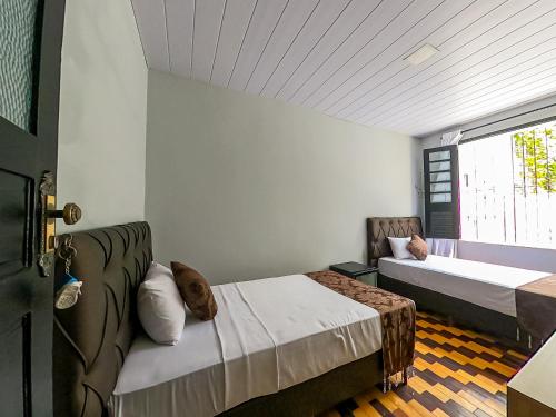 a bedroom with two beds and a window at Hotel Filha do Cacique in Belém